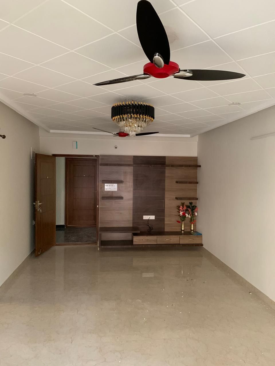 Living hall with crystal chandelier, designer ceiling fan and walnut TV unit