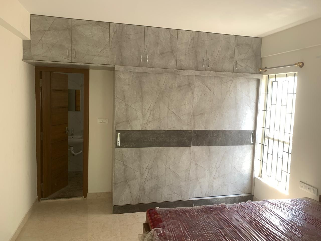 Bedroom with grey marble-laminate sliding wardrobe and ensuite