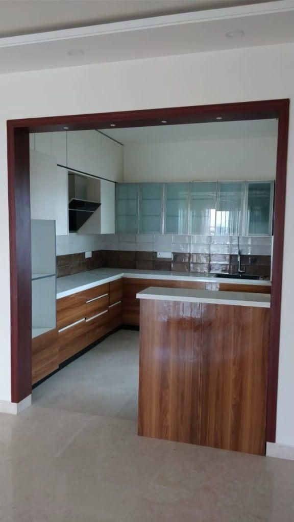 Walnut and glass-front U-shaped modular kitchen with marble backsplash