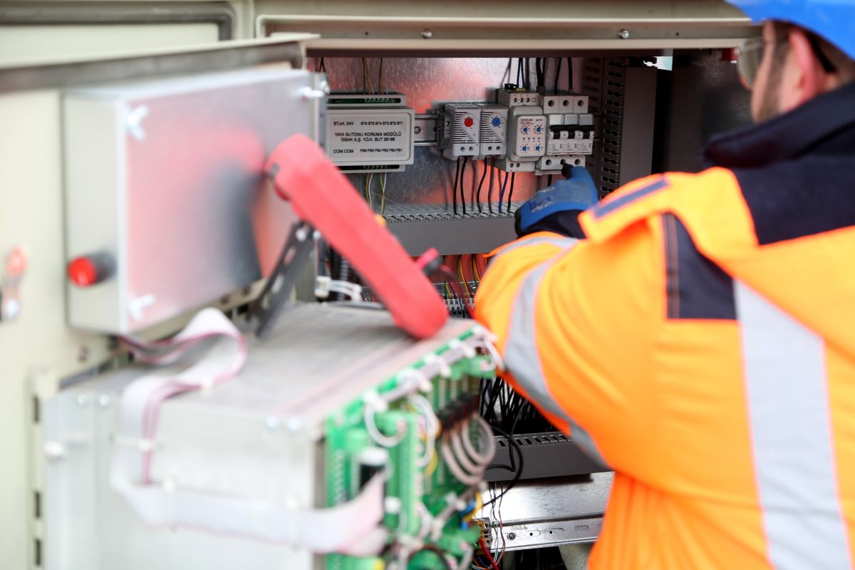 Technician maintaining an inverter and battery backup unit