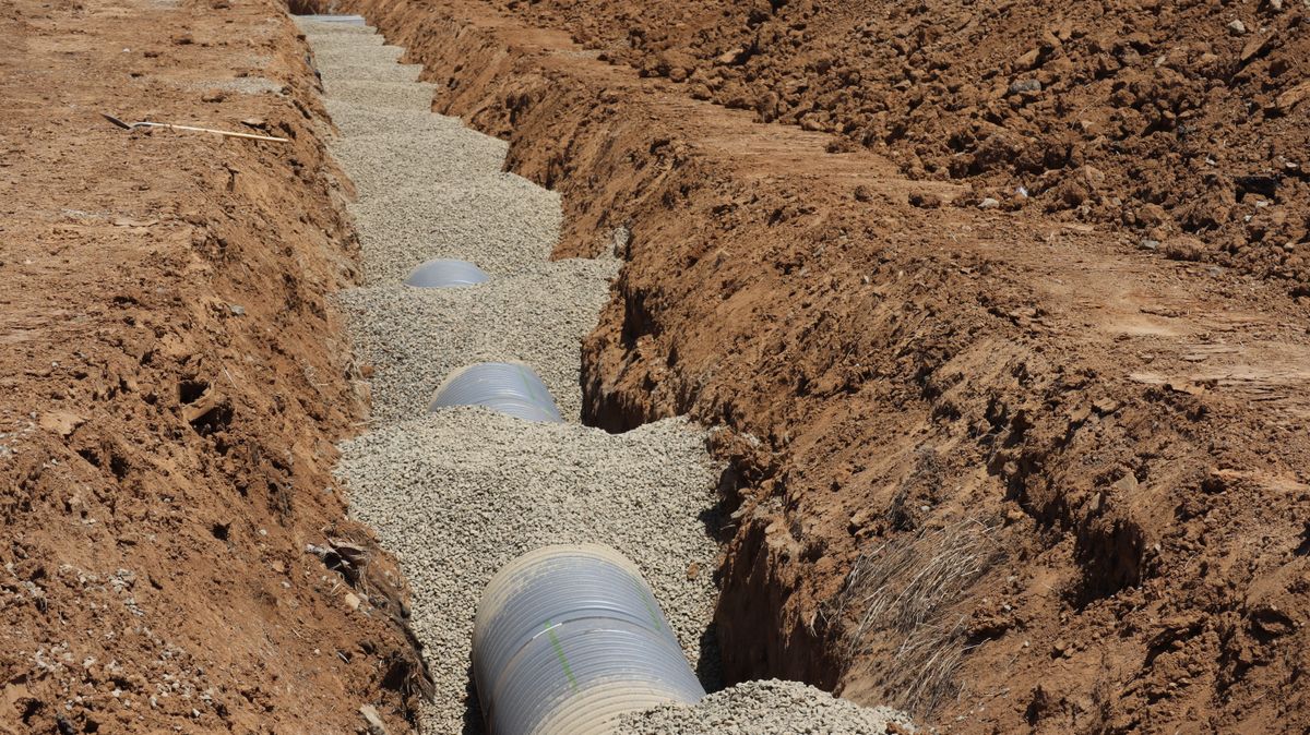 Drainage pipe being laid in a construction trench